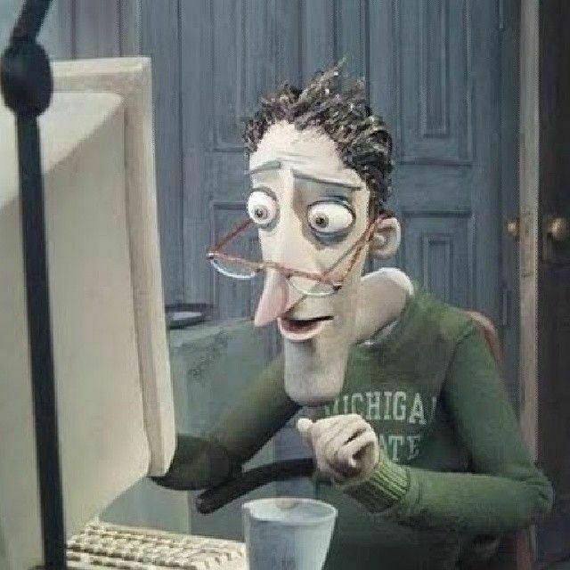 The dad from the movie Coraline, sitting slumped in front of his computer screen, looking surprised with his hand poised over the computer keyboard. 