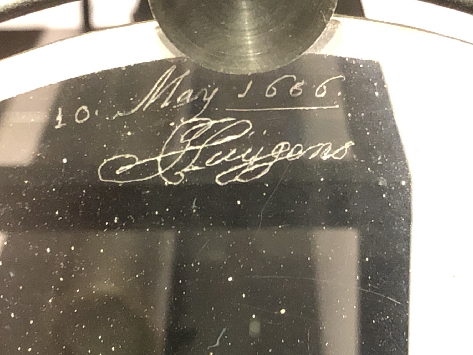 A signature by Christiaan Huygens scratched in cursive script into the edge of one of his lenses. The handwriting is beautiful cursive script, with the date 1666.