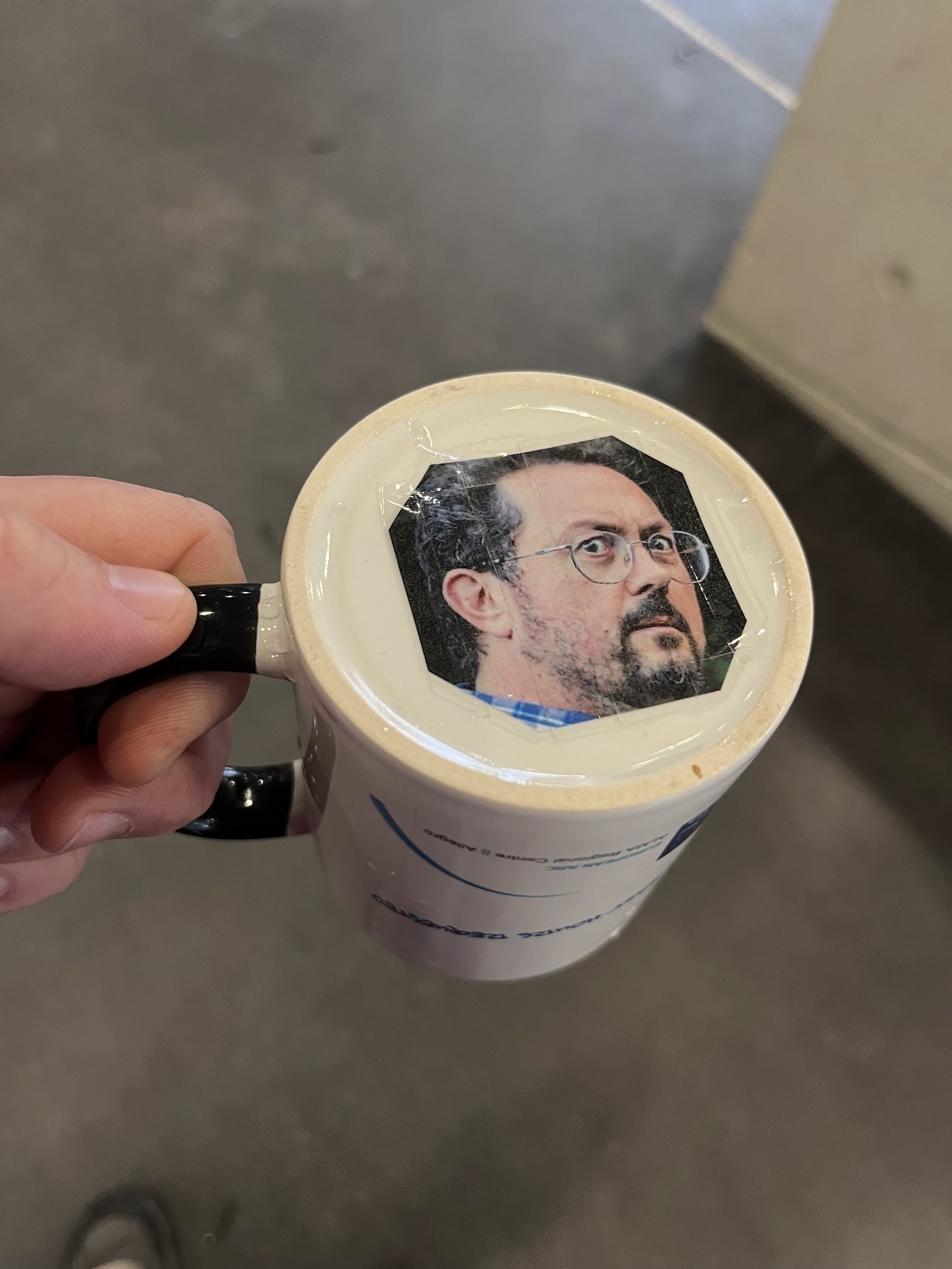 A photo of me looking grumpy, stuck onto the bottom of my coffee mug. 