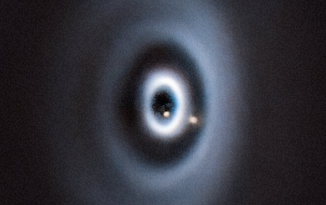 Composite showing two red dots, representing the exoplanets WISPIT 2b and 2c, embedded in the white ellipses of scattered light.