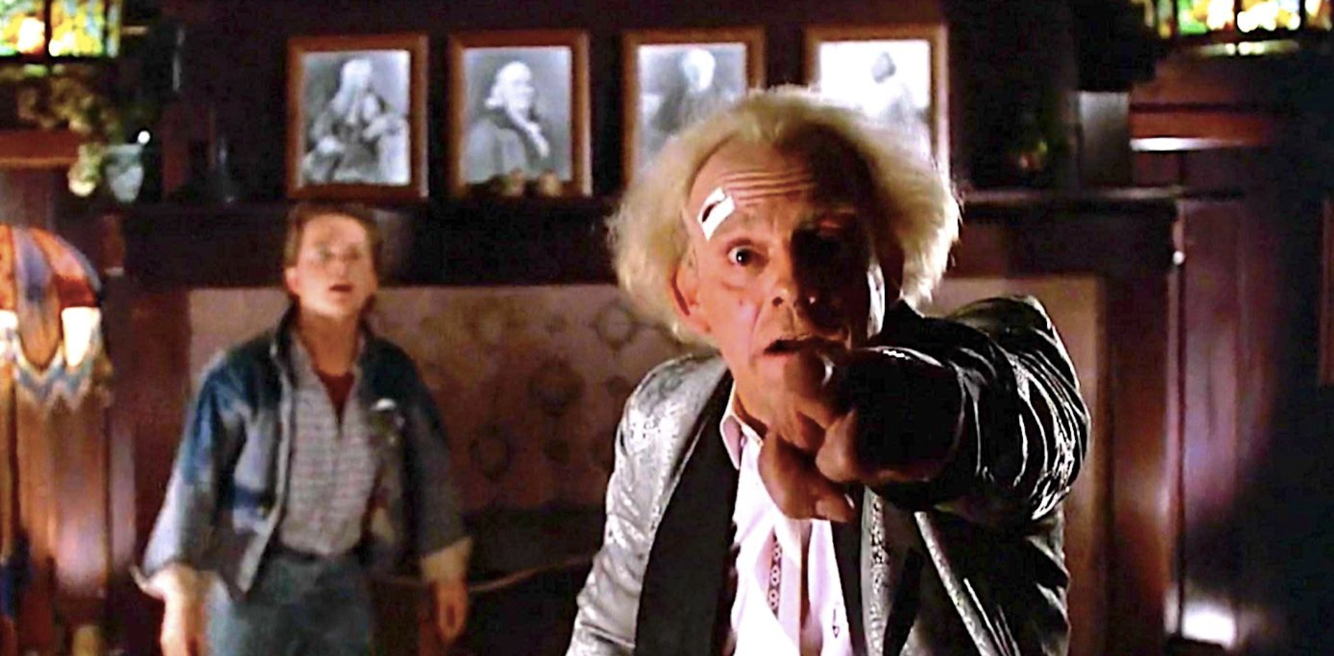 Marty looking shocked and out of focus whilst Doc Brown breaks the fourth wall with his finger saying the name of the film.